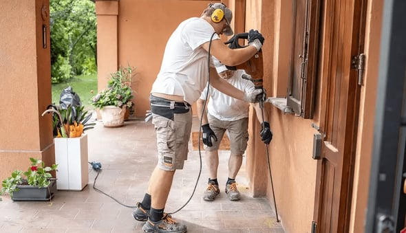 Uretek Mitarbeiter bringen die Injektionsrohre durch Vibration in die Bohrlöcher